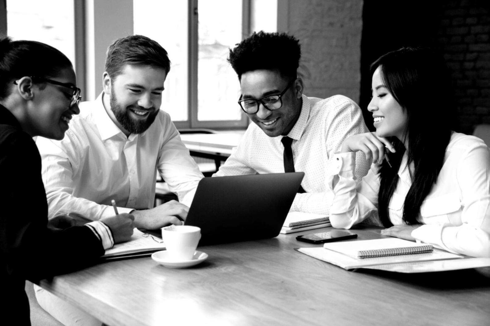 Personas trabajando colaborativamente en conceptos financieros, con gráficos y documentos sobre una mesa moderna