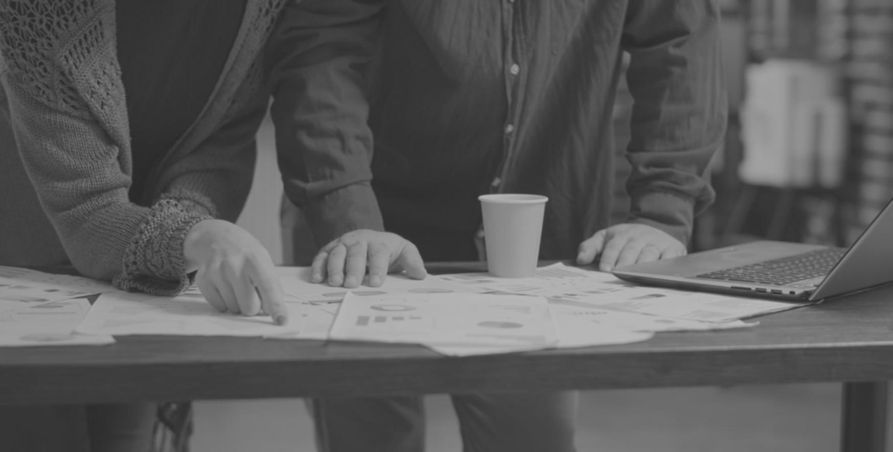 Persona organizando documentos financieros en su escritorio